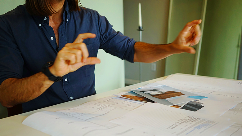 Person Reviewing Architectural Plans While Making Their Point